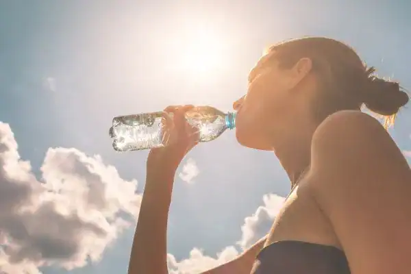 Hydration: The Secret Ingredient for a Toned Stomach and Enhanced Fitness 3 Image of woman drinking water to hydrate Knutsford after run.