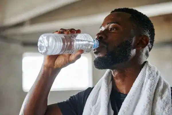 Hydration: The Secret Ingredient for a Toned Stomach and Enhanced Fitness 1 Image of man drinking water to improve hydration Knutsford after work out.